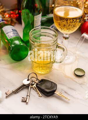 Ein weihnachtliches, festliches Getränkekonzept mit Autoschlüsseln auf einem Tisch voller alkoholischer Getränke und Dekorationen. Stockfoto