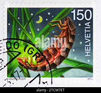 MOSKAU, RUSSLAND - 19. NOVEMBER 2023: Briefmarke gedruckt in der Schweiz zeigt Gemeiner Glühwürmchen (Lampyris noctiluca), nächtliche Tiere Serie, ca. 2 Stockfoto