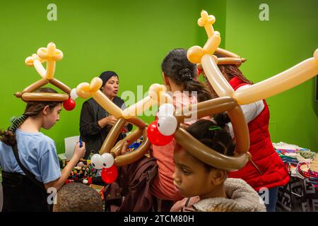 Detroit, Michigan - das südwestliche Detroit Holiday fest im mexikanisch-amerikanischen Viertel. Kinder trugen rentierförmige Ballons. Stockfoto