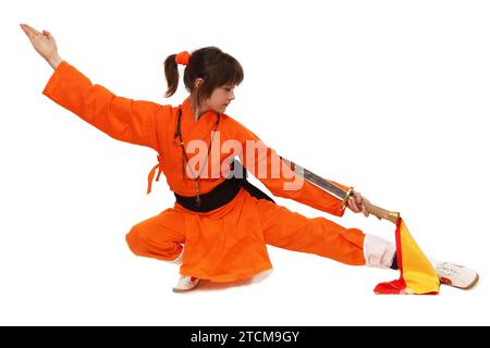 Wushu-Mädchen in Orange machen Übung von Shaolin Taolu Stockfoto