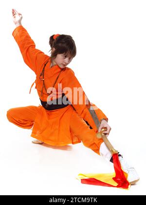 Wushu-Mädchen in Orange machen Übung von Shaolin Taolu Stockfoto