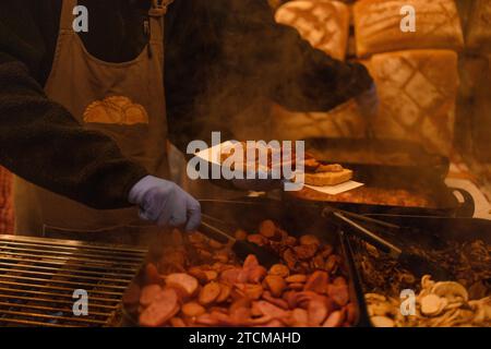 Traditionelles polnisches Rundbrot an einem Weihnachtsmarkt in Krakau, Polen. Traditionelles polnisches Street Food, Sandwiches mit Würstchen und Zwiebeln. Stockfoto