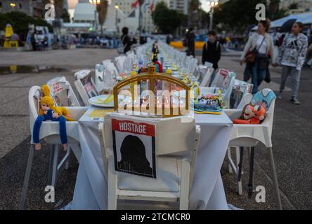 Tel Aviv, Israel. Dezember 2023. Ein Hanukkiah-Leuchter wird in der Nacht vor dem jüdischen Feiertag von Hanukka mit Kerzen beleuchtet, dem Lichterfest, endet an der Spitze eines leeren Tisches für die 137 verbleibenden israelischen Geiseln, die am 13. Dezember 2023 im Gazastreifen auf dem Geiselplatz im Tel Aviv Museum in Tel Aviv, Israel, festgehalten wurden. Der leere Tisch steht für die vermissten Geiseln, die Israel während des Angriffs der Hamas auf Süd-Israel am 7. Oktober 2023 entführt wurden. Foto von Jim Hollander/UPI Credit: UPI/Alamy Live News Stockfoto