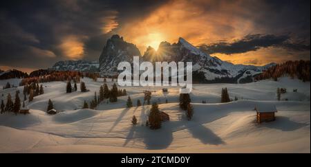 Ansicht der traditionellen Holz- Mountain Chalets an der malerischen Seiser Alm mit Langkofel Berg bei Sonnenaufgang, Dolomiten, Südtirol, Italien Stockfoto