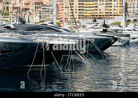 Sonnenstrahlen auf Hochglanzbooten, azurblaues Wasser, Ruhe im Hafen Herkules, Bögen von verankerten Booten an sonnigen Tagen, Megayachten, Monaco, Monte-Carlo Stockfoto