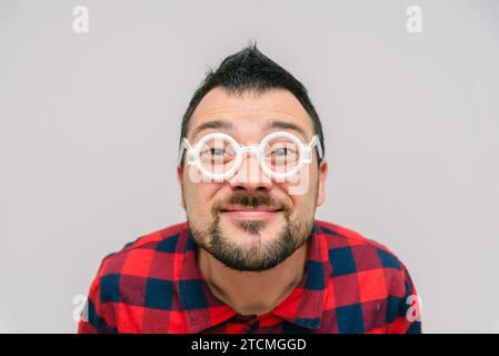 Lustiger lächelnder Mann mit Brille Porträt genießt und macht Gesichter Stockfoto