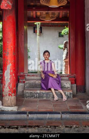 Elegante junge vietnamesische Studentin posiert für Fotos am Abschlussfeiertag im Tempel der Literatur in Hanoi Stockfoto