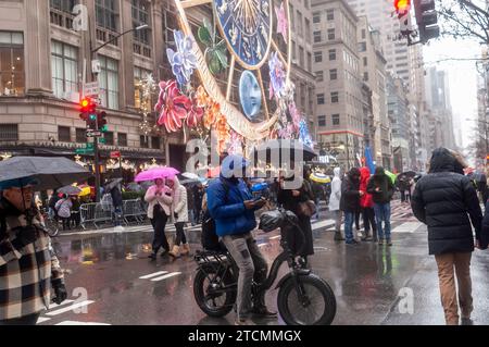 Tausende von Touristen und New Yorkern trotzen dem regnerischen Wetter und strömen in die autofreie Fifth Avenue in Midtown Manhattan, um die Holiday Open Streets am Sonntag, den 3. Dezember 2023, zu genießen. New York City schloss einen neun Blocks langen Abschnitt der Fifth Avenue in Midtown für vier Sonntage im Dezember für Fahrzeuge und bildete so eine Feiertagsfeier für Besucher. (© Richard B. Levine) Stockfoto