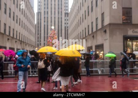 Tausende von Touristen und New Yorkern trotzen dem regnerischen Wetter und strömen in die autofreie Fifth Avenue in Midtown Manhattan, um die Holiday Open Streets am Sonntag, den 3. Dezember 2023, zu genießen. New York City schloss einen neun Blocks langen Abschnitt der Fifth Avenue in Midtown für vier Sonntage im Dezember für Fahrzeuge und bildete so eine Feiertagsfeier für Besucher. (© Richard B. Levine) Stockfoto