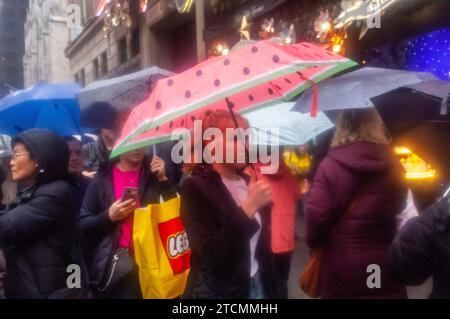 Tausende von Touristen und New Yorkern trotzen dem regnerischen Wetter und strömen in die autofreie Fifth Avenue in Midtown Manhattan, um die Holiday Open Streets am Sonntag, den 3. Dezember 2023, zu genießen. New York City schloss einen neun Blocks langen Abschnitt der Fifth Avenue in Midtown für vier Sonntage im Dezember für Fahrzeuge und bildete so eine Feiertagsfeier für Besucher. (© Richard B. Levine) Stockfoto