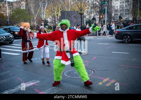 Hunderte von Santas, begleitet von ihren Helfern und einigen frechen Elfen, marschieren in Manhattan in New York ein, um am Samstag, den 19. Dezember 2023, die jährliche Bar-Crawl, SantaCon, zu veranstalten. Die SantaCon, in erster Linie ein Kneipenbummel in Weihnachtskostümen und anderen Weihnachtskostümen, zieht Maskierer an, die von Bar zu Bar gehen. (© Richard B. Levine) Stockfoto