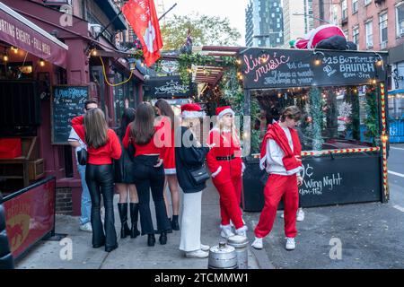 Hunderte von Santas, begleitet von ihren Helfern und einigen frechen Elfen, marschieren in Manhattan in New York ein, um am Samstag, den 19. Dezember 2023, die jährliche Bar-Crawl, SantaCon, zu veranstalten. Die SantaCon, in erster Linie ein Kneipenbummel in Weihnachtskostümen und anderen Weihnachtskostümen, zieht Maskierer an, die von Bar zu Bar gehen. (© Richard B. Levine) Stockfoto