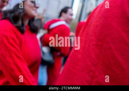 Hunderte von Santas, begleitet von ihren Helfern und einigen frechen Elfen, warten online, um die Smith Bar im Nomad-Viertel in Manhattan in New York während des jährlichen Kneipenbummels SantaCon am Samstag, den 19. Dezember 2023, zu betreten. Die SantaCon, in erster Linie ein Kneipenbummel in Weihnachtskostümen und anderen Weihnachtskostümen, zieht Maskierer an, die von Bar zu Bar gehen. (© Richard B. Levine) Stockfoto