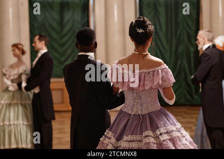 Rückansicht der klassischen Dame und Gentleman, die den Ballsaal im Palast betreten, Kopierraum Stockfoto