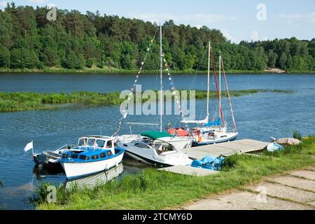 Der Sommerblick auf Motorboote und Segelboote, die am kleinen Pier im Fluss Neman, Ferienort Birstonas (Litauen) ankern. Stockfoto