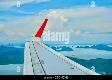 Der Flügel eines Flugzeugs fliegt über Krabi, Phang Nga Bay und die Inseln der Andamanensee auf dem Weg nach Phuket an einem sonnigen, aber trüben Tag Stockfoto