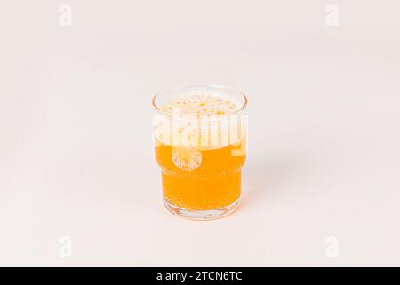 Orange Vitamin-C-Brausetabletten fallen gelassen und lösen sich in einem Glas Wasser mit Blasen auf weißem Hintergrund auf Stockfoto