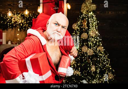 Weihnachten und Neujahrsgrüße von der Polizeiwache. Weihnachtsmann in der Maske mit Tasche. Weihnachtliche Sicherheit vor Einbrechern und Haussicherheit. Stockfoto