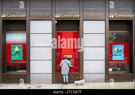 Ein Kunde nutzt den Geldautomaten der spanischen multinationalen Geschäftsbank und die Finanzdienstleistungen der Santander-Niederlassung in Spanien. Stockfoto