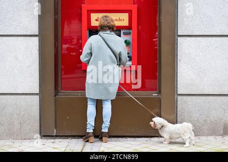 Ein Kunde nutzt den Geldautomaten der spanischen multinationalen Geschäftsbank und die Finanzdienstleistungen der Santander-Niederlassung in Spanien. Stockfoto