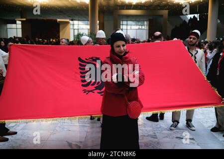 Tirana, Albanien - 28. November: Eine albanische Frau posiert vor einer großen Nationalflagge während der Feierlichkeiten zum Unabhängigkeitstag auf dem Nene Tereza Kongress Stockfoto