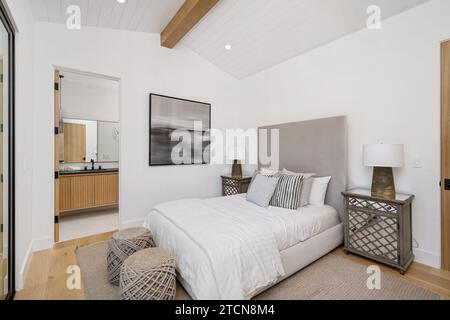 Dieses moderne Schlafzimmer mit Hartholzboden und weißen Wänden ist klassisch eingerichtet Stockfoto