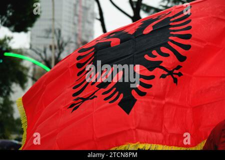 Foto mit der albanischen Flagge, die im Wind winkt, in einer Umgebung im Freien, in der die leuchtenden roten und schwarzen Farben hervorgehoben werden Stockfoto