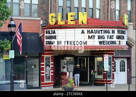 Glen Ellyn, Illinois, USA. Ein kleiner Junge zeigt auf die Plakate der Filme, während seine Mutter am Eintrittsschalter Tickets kauft. Stockfoto