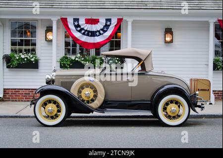 Der Ford Model A Roadster 1930 parkte in der Nähe von patriotischen roten, weißen und blauen Fahnen. Stockfoto