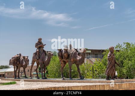 26. JUNI 2023, CHIWA, USBEKISTAN: Statuen der Kamelkarawane, die durch die alte Seidenstraße in der Altstadt von Chiwa fahren Stockfoto