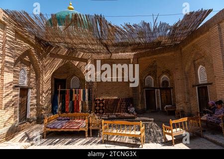 26. JUNI 2023, CHIWA, USBEKISTAN: Usbekische Frauen, die sich im Hinterhof des Hauses in Chiwa entspannen Stockfoto