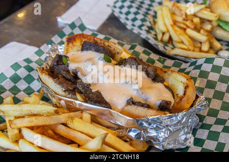 Closeup Philly Cheesesteak Sandwich (Philadelphia Cheesesteak) und Pommes frites. Stockfoto