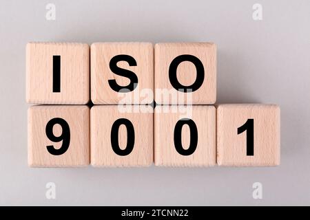 Internationale Organisation für Normung. Holzwürfel mit Abkürzung ISO und Nummer 9001 auf hellgrauem Hintergrund, flach angelegt Stockfoto