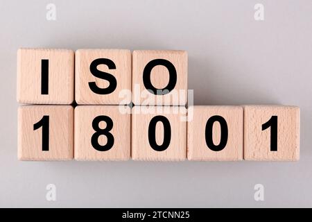 Internationale Organisation für Normung. Holzwürfel mit Abkürzung ISO und Nummer 18001 auf hellgrauem Hintergrund, flach angelegt Stockfoto