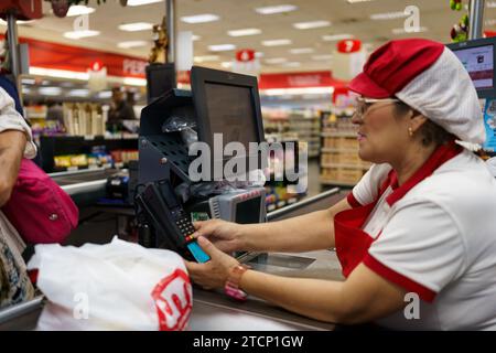 Caracas, Venezuela. Dezember 2023. Die Kassen in einem Supermarkt werden gesehen, als die Leute Lebensmittel einkaufen. Nach einem kurzen Boom dank der Dollarisierung der Wirtschaft ist Venezuelas wirtschaftliche Lage mit einer jährlichen Inflation von 398 % und einem Rückgang der Wirtschaftstätigkeit um 7 % immer noch beunruhigt. Mit einem Mindestlohn von nur 8 Dollar kämpft ein Großteil der Bevölkerung immer noch darum, das Ende des Monats zu erreichen. (Foto: Davide Bonaldo/SIPA USA) Credit: SIPA USA/Alamy Live News Stockfoto