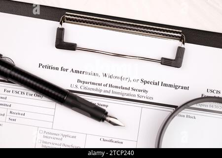 I-360 Petition für Amerasian-, Witwer- oder spezielle Einwanderungsleerform auf A4-Tablette liegt auf dem Bürotisch mit Stift und Lupe in Nahaufnahme Stockfoto