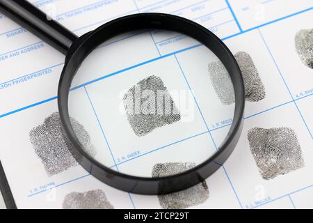 Fingerabdrücke Karte Polizeiformular auf A4-Tablet liegt auf dem Bürotisch mit Stift und Lupe nah oben Stockfoto