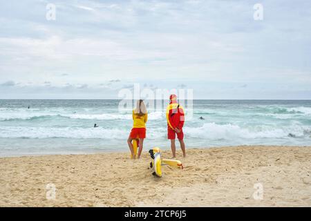 Sydney, NSW, Australien - 2. Dezember 2023: Zwei Freiwillige des Bondi Surf Bader Life Saving Club auf Patrouille am Strand an einem bewölkten Tag Stockfoto