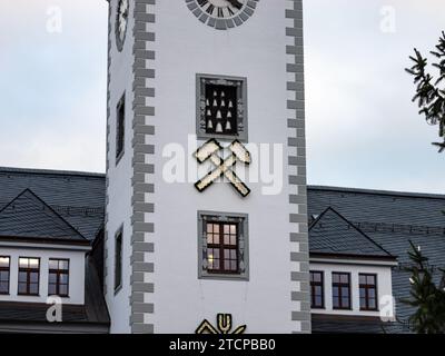 Bergbausymbol auf dem Rathaus. Das Hammer- und Pick-Logo wird während der Weihnachtszeit beleuchtet. Urlaubstradition in Freiberg. Stockfoto