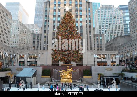 New York City, Usa. Dezember 2023. Die Leute laufen unter dem Weihnachtsbaum im Rockefeller Center. Während der Weihnachtszeit besuchen Shopper, Reisende und Einheimische Geschäfte und Attraktionen in Midtown Manhattan, New York City. (Foto: Jimin Kim/SOPA Images/SIPA USA) Credit: SIPA USA/Alamy Live News Stockfoto