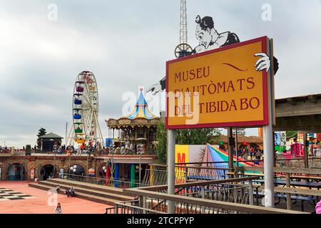 Schild mit Inschrift Automatenmuseum, Vergnügungspark, Vergnügungspark mit Riesenrad und Touristen, bewölkter Himmel im Herbst, Tibidabo Stockfoto