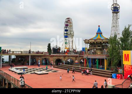 Vergnügungspark, Vergnügungspark mit Riesenrad und Touristen, bewölkter Himmel im Herbst, Tibidabo, Barcelona, Spanien Stockfoto