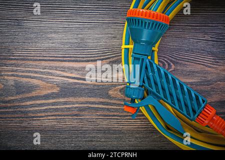 Handspritzgartengummischlauch auf Holzbrett Landwirtschaftskonzept Stockfoto