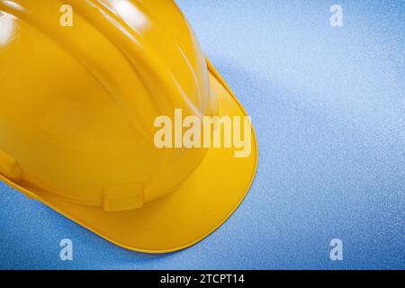 Gelber Schutzhelm auf blauem Oberflächenkonzept Stockfoto