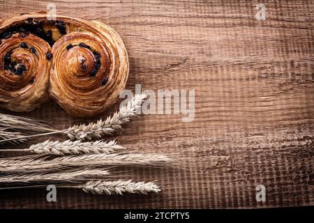 Frisch gebackene Sultanarollen Haufen Weizenohren auf Eichenbrett Food and Drink Konzept Stockfoto