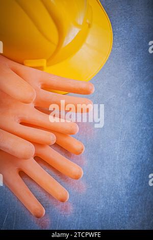 Isolierende Handschuhe Sicherheitshelm auf metallischem Hintergrund Stockfoto