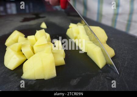 Zubereitung einer Kressensuppe, Schneiden roher Kartoffeln, Schneidebrett, Küchenmesser, Zerkleinern, schwäbische Küche, deftige Suppe, vegetarisch, gesund Stockfoto