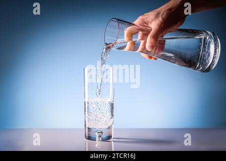 Gießen trinken Wasser aus einem Krug in ein Glas. Sauberes Trinkwasser Konzept Stockfoto