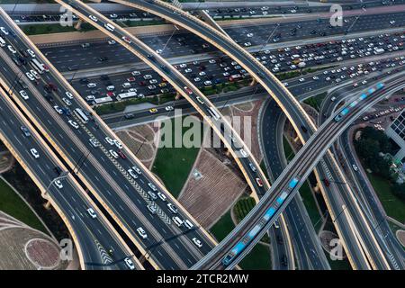 Der Autoverkehr ist im Zentrum von Dubai, der Sheikh Zayed Road und ihren Autobahnkreuzen in den Vereinigten Arabischen Emiraten an einem heißen Tag, dem 13. Dezember 2023, zu beobachten. Die Aussicht vom Sky Views Observatory. Stockfoto