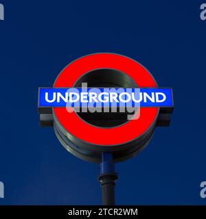 Beleuchtete Verkehrsmittel für London TfL unterirdisches Rundfunkschild in London, England, Großbritannien bei Nacht. Stockfoto